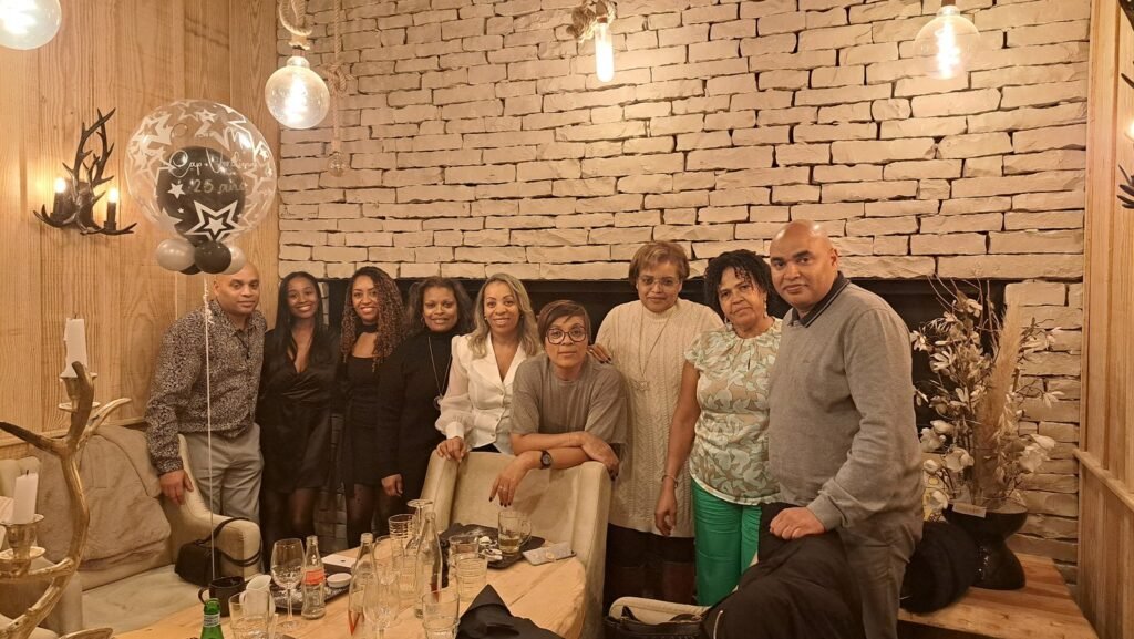 O comité e os convidados à volta da mesa comprida do jantar dos vinte e cinco anos.
